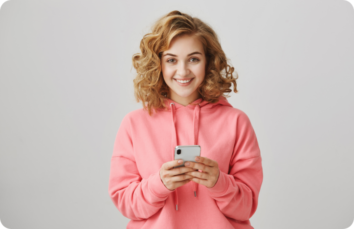 happy female with curly blonde hair in pink hoodie